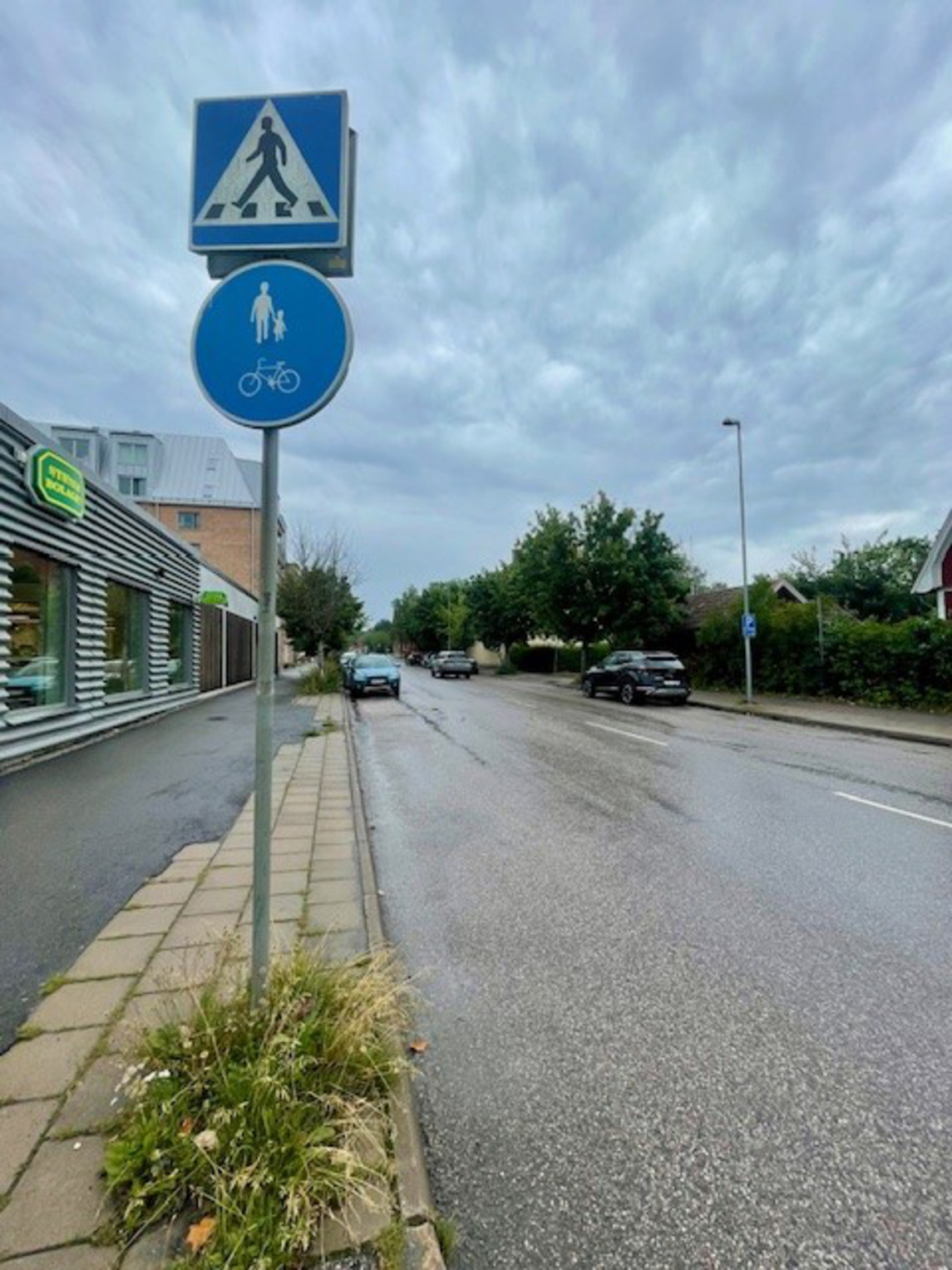 Väg med parkerade bilar, Systembolaget till vänster.