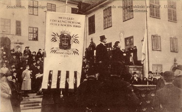 Bondetåget 1914. Enligt text på framsidan "Stockholm, Bondetåget. Upplands standar, skänkt av K.F.U.K, överlämnas". Fotograf: okänd/Bohusläns museum