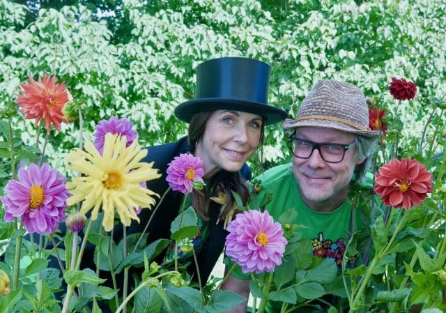 En man och en kvinna med hatt bland färgglada blommor