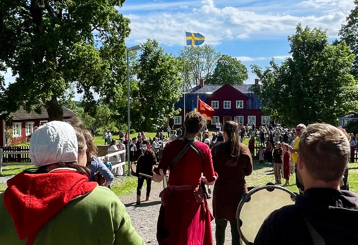 Människor i medeltidskläder går mot Tilasgården 