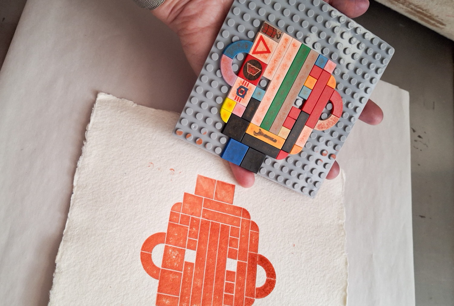 Legobitar som skapar ett tryck i färg på papper