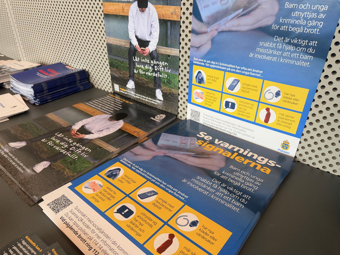 Affischer om gängkriminalitet och ungdomar på ett bord.