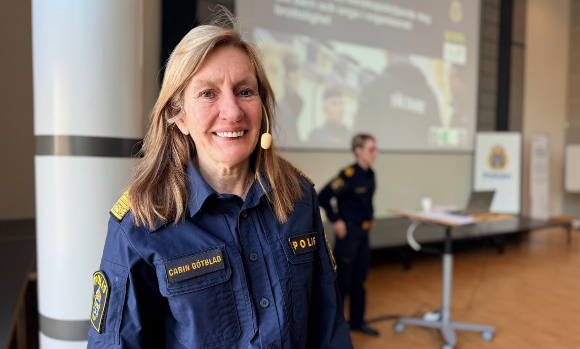 Kvinna i poliskläder med ett headset i örat.