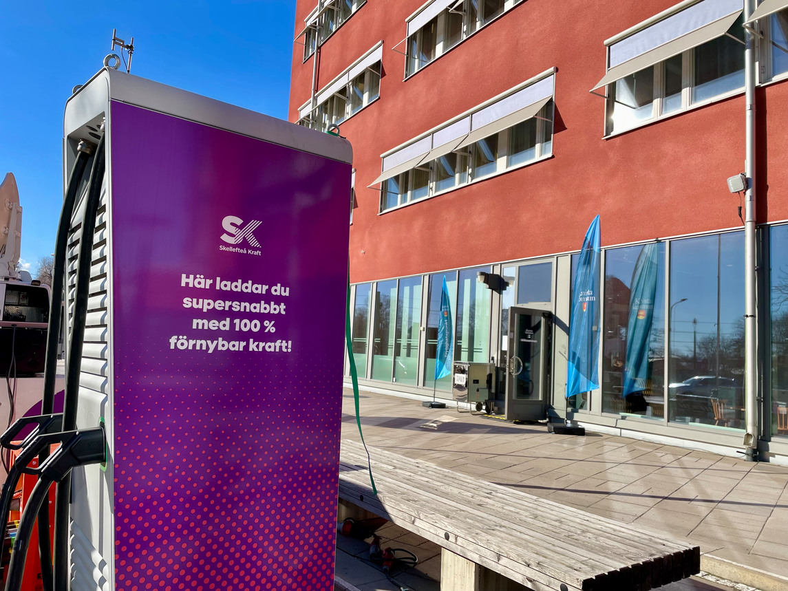 En lila laddstation utanför ett rött kommunhus
