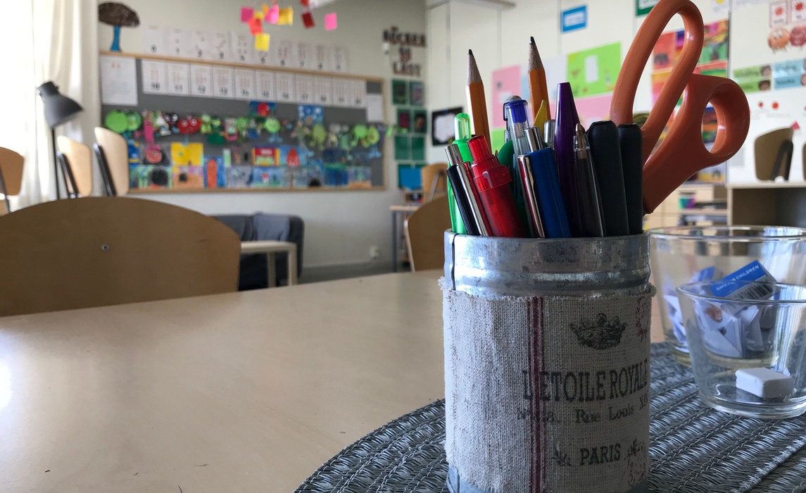 Klassrum med pennor i förgrunden 